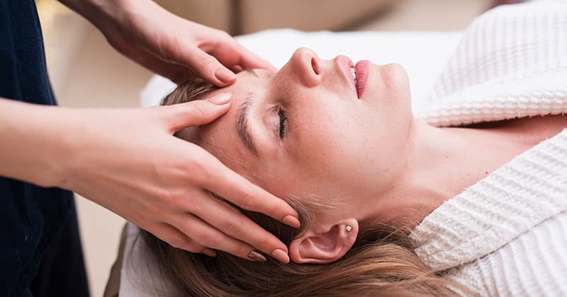 Séance d’hypnose thérapeutique relaxante en cabinet, femme allongée les yeux fermés, accompagnée avec douceur